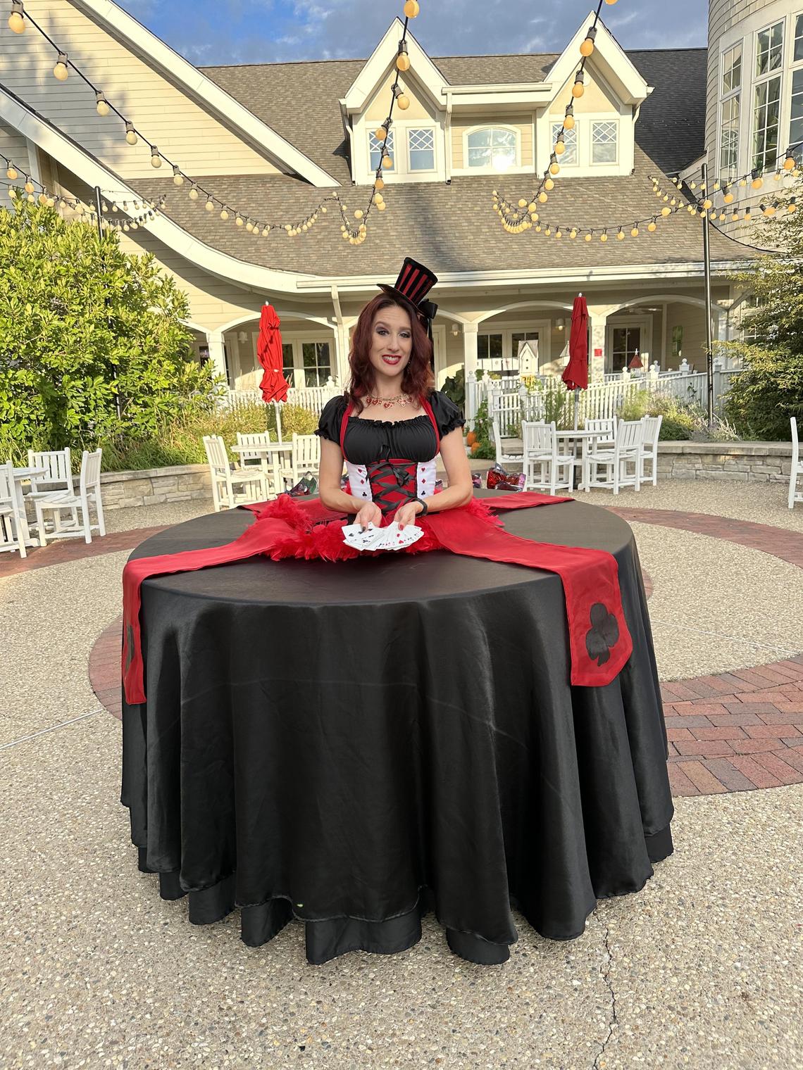 Casino themed strolling table plays cards for candy coins